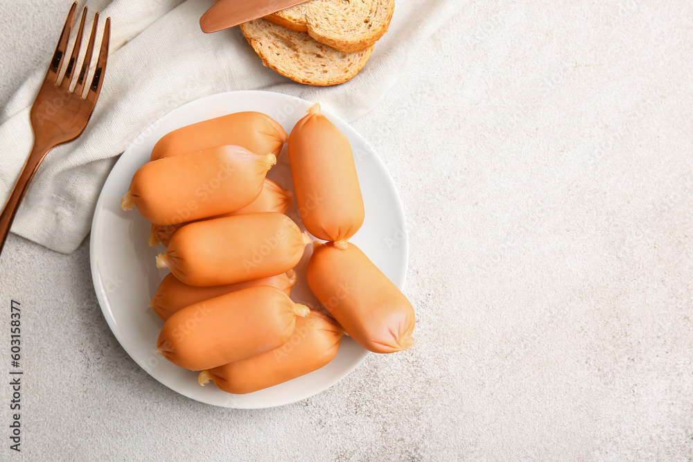 Plate of tasty boiled sausages on grey background