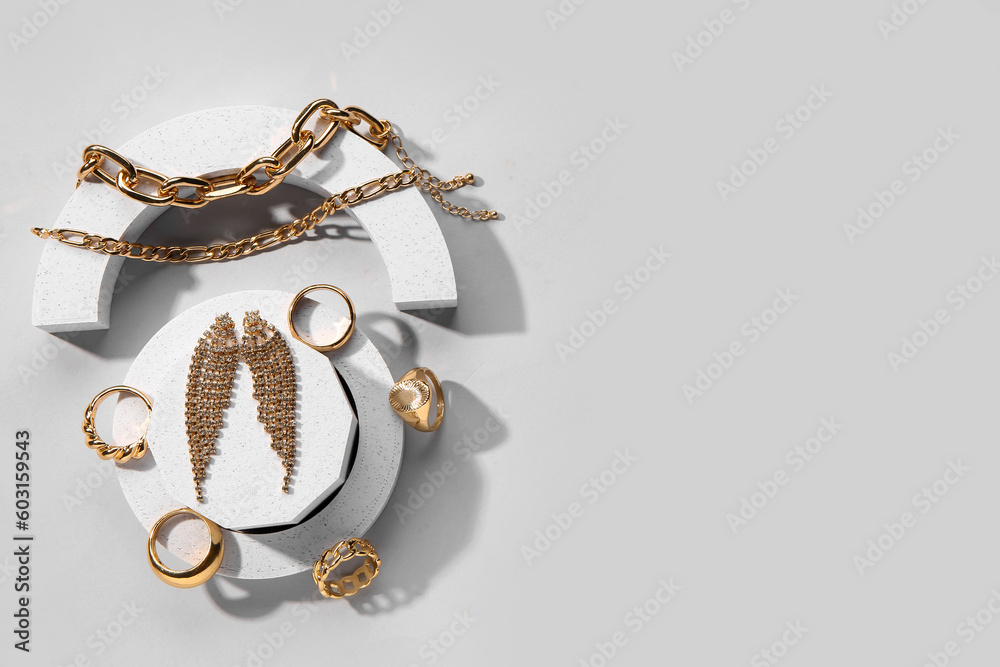 Decorative podiums with beautiful jewellery on grey background