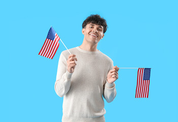 Wall Mural - Young man with USA flags on blue background