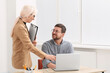 © New Africa - Boss and employee with laptop discussing work issues in office