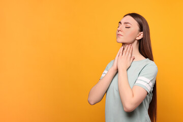 Poster - Young woman with sore throat on orange background. Space for text