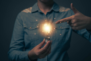 Poster - Glowing light bulb in hand, idea search concept Creativity from information trade in the internet world, marketing, business ideas and target groups.