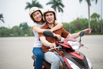 Wall Mural - Young Asian couple on the motorbike