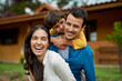 © Camerene P/peopleimages.com - Portrait, outdoor and family with happiness, funny and bonding with joy, laughing and loving. Face, parents and mother with father, male child or boy outside, house and real estate with weekend break