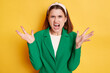 © sementsova321 - Angry irritated woman wearing green jacket posing isolated over yellow background arguing screaming with hate raised her arms yelling with anger.