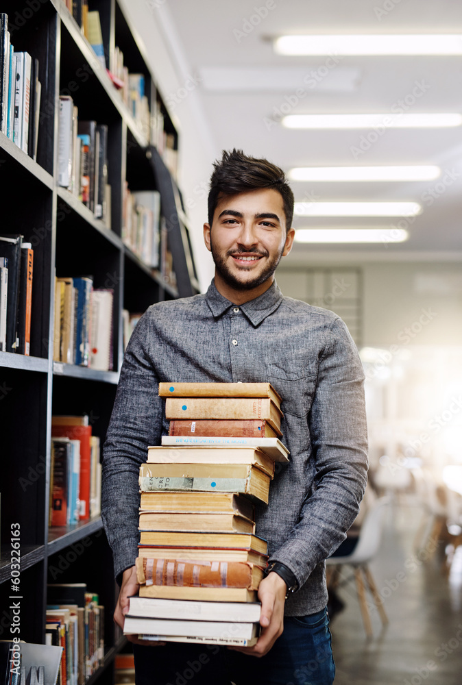 Man in portrait, college student with stack of books in library and ...