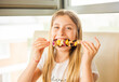 girl eating chicken skewer with pineapple at home