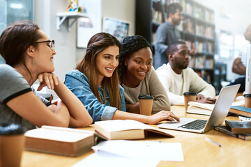 Women, students in library with laptop and studying for exam or research for project with education. Young female people in study group, search internet on pc and learning on university campus