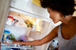 © Stratford/peopleimages.com - Woman, search fridge and food with smile, hungry and thinking for diet, meal and choice in home kitchen. Young african girl, happy and decision for breakfast, lunch or dinner in house for nutrition