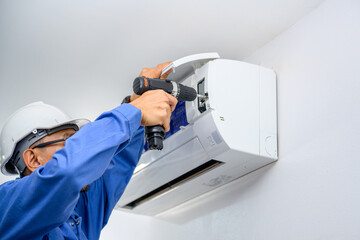 A male air conditioner technician or air conditioning installation. technician is about to repair air conditioning in homes and buildings.