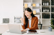 © Nuttapong punna - Asian business woman are delighted and happy with the work they do on their tablet, laptop and taking notes at the office..