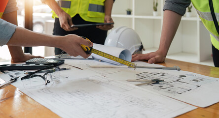 Wall Mural - engineer people meeting working and pointing at a blueprint in office for discussing. Engineering tools and construction concept