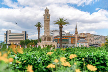 Izmir, Turkey - April 28 2023: Konak Square With Old Clock Tower And Mosque Just Above The Flowers In The Spring