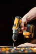 © Elena - side view of a drill and an electric drill-driver with a replaceable battery held by a worker's hand