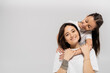 © LIGHTFIELD STUDIOS - happy preteen daughter with brunette hair embracing cheerful mother with tattoo on hand and looking at camera on grey background, Child protection day, mother and daughter