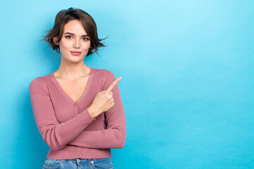 Poster - Photo of sweet cute lady wear pink cardigan showing finger empty space isolated blue color background