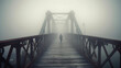 A hazy picture of a person walking on a foggy bridge