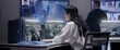 © Framestock - Female security officer works on computer in police monitoring center. Multi ethnic workers control surveillance CCTV cameras with tracking AI face recognition system on tablet and big digital screen.