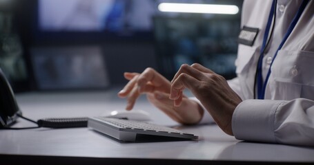 Female security operator works in police monitoring center. Woman types on keyboard, uses landline phone and walkie talkie. Computer and digital tablet screens with CCTV cameras footage on background.