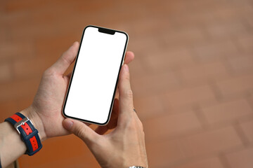 Poster - Close up and cropped image of male's hands holding a mobile phone, Empty screen of device for advertising.