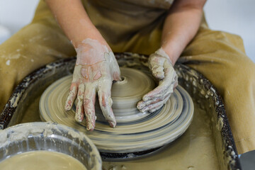 close up view of professional potter working on pottery wheel at workshop. High quality photo