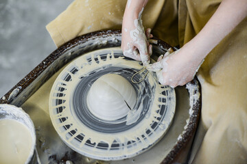 close up view of professional potter working on pottery wheel at workshop. High quality photo