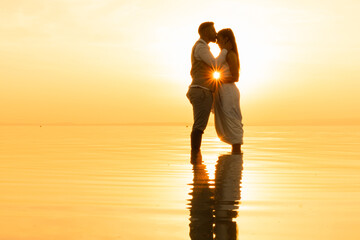 loving couple enjoy sunset standing in shallow lake water