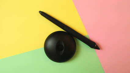 Color paper background with a digital drawing pen and a pen stand holder