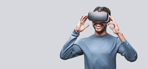 Young man using virtual reality headset isolated over gray background, VR, future, gadgets, technology concept