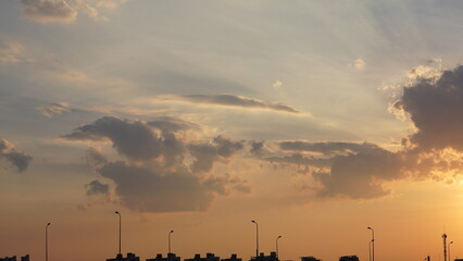 Wall Mural - the beautiful sunset view with the buildings' silhouette and orange color sky as background in the c