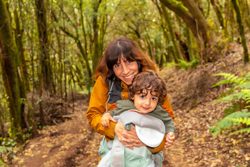 Wall Mural - Mother and son having fun on the trail in the mossy tree forest of Garajonay National Park, La Gomera, Canary Islands