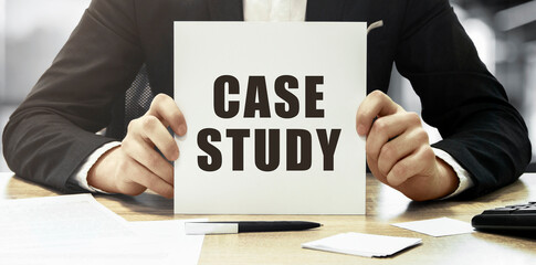 Aufkleber - Businessman holding a white card with text Case study on office background