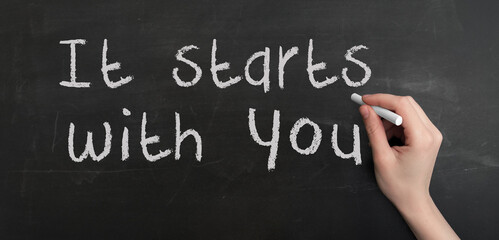Aufkleber - A woman's hand write text It starts with you with chalk on chalkboard