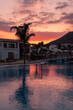 sunset over a hotel pool greece greek kos island kardamena palm trees seaside pink skies sky clouds landscape swimming luxurious
