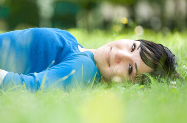 Poster - attractive woman relaxing on grass in park