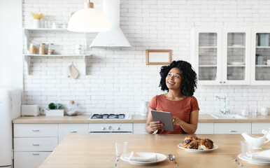 Poster - Smart Home Concept. Young black woman controlling house light with digital tablet