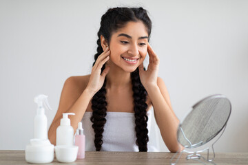 Wall Mural - Self-Care Concept. Attractive Young Indian Woman Looking In Mirror At Home