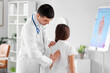 © Pixel-Shot - Doctor checking posture of little girl in clinic