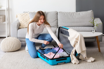 Sticker - Young woman unpacking suitcase at home