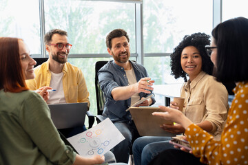 Group of happy students studying together, education. Smiling multiracial business people talking, planning startup, sharing ideas working in modern office. Meeting, teamwork, successful business