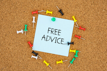 Poster - Free advice text on light blue post-it paper pinned on bulletin cork board surrounding by multi color pins. This message can be used in business concept about free advice.