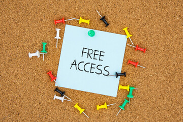 Poster - Free access text on light blue post-it paper pinned on bulletin cork board surrounding by multi color pins. This message can be used in business concept about free access.