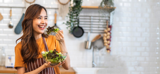 Wall Mural - Portrait of beauty body slim healthy asian woman having fun cooking and preparing cooking vegan food healthy eat with fresh vegetable salad in kitchen at home.Diet concept.Fitness, wellness, healthy