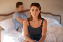 Sad, Upset And Couple In An Argument In Their Bedroom For Divorce Or Breakup In A Modern House. Toxic, Mad And Face Of A Woman Fighting And In Conflict With Her Boyfriend In Bed In Their Home.