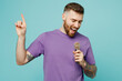 Young cheerful fun happy singer man he wears purple t-shirt sing song in microphone at karaoke club isolated on plain pastel light blue cyan background studio portrait Tattoo translates life is fight