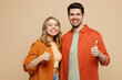 © ViDi Studio - Young smiling happy couple two friend family man woman wear casual clothes looking camera together showing thumb up like gesture isolated on pastel plain light beige color background studio portrait