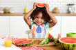 © Lisa Tichané - Cute toddler girl holding slice of watermelon above head