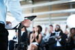© Koegelenberg/peopleimages.com - Closeup, business and man with a crowd, presentation and conference with information, motivation and event. Zoom, male person and staff in a workshop, speaker and presenter with ideas and audience