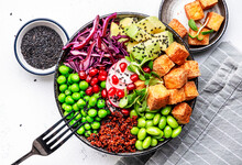 Healthy Vegan Food. Buddha Bowl With Quinoa, Fried Tofu, Avocado, Edamame, Green Peas, Radish, Cabbage And Sesame Seeds. White Kitchen Table Background, Top View