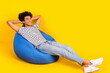 Full body photo of young student chilling dormitory hands head take nap after lectures sitting pouf isolated on yellow color background